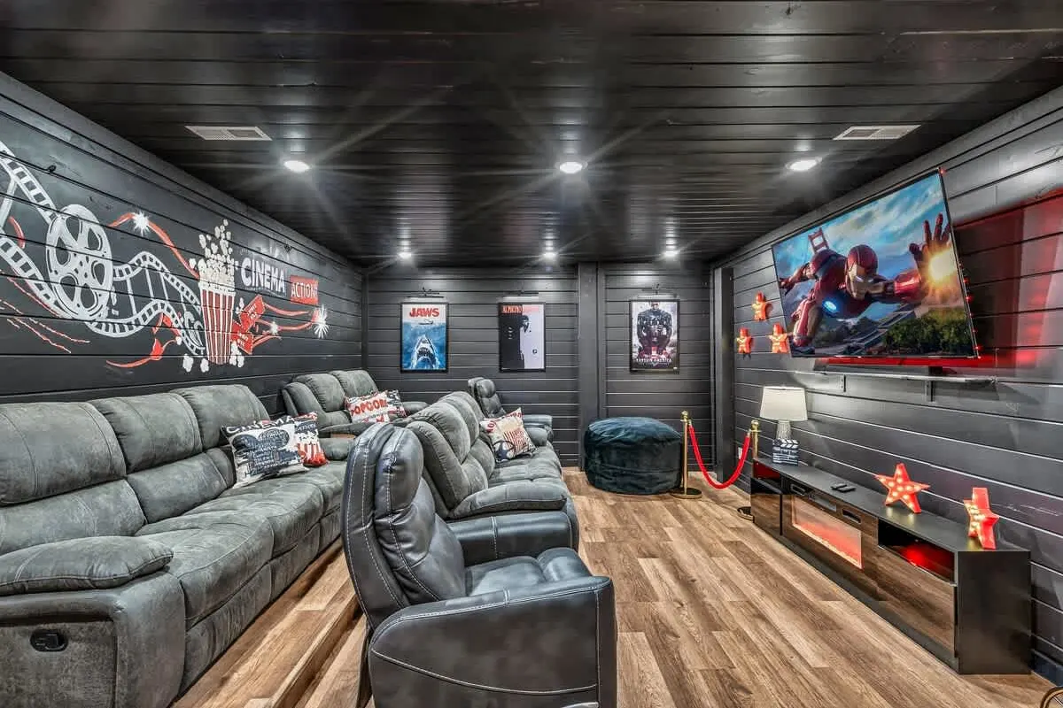 Theater room at Big Star Lodge with reclining sectionals and a hand-painted cinema wall