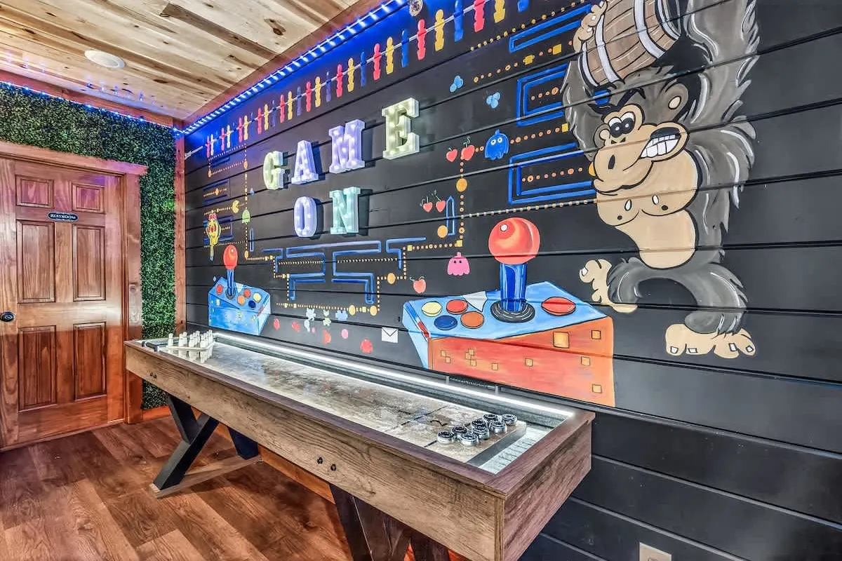 Arcade wall at Big Star Lodge with neon GAME ON sign and a shuffleboard table