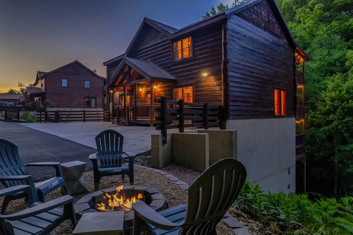 Big Star Lodge exterior at dusk with a lit fire pit and Adirondack chairs
