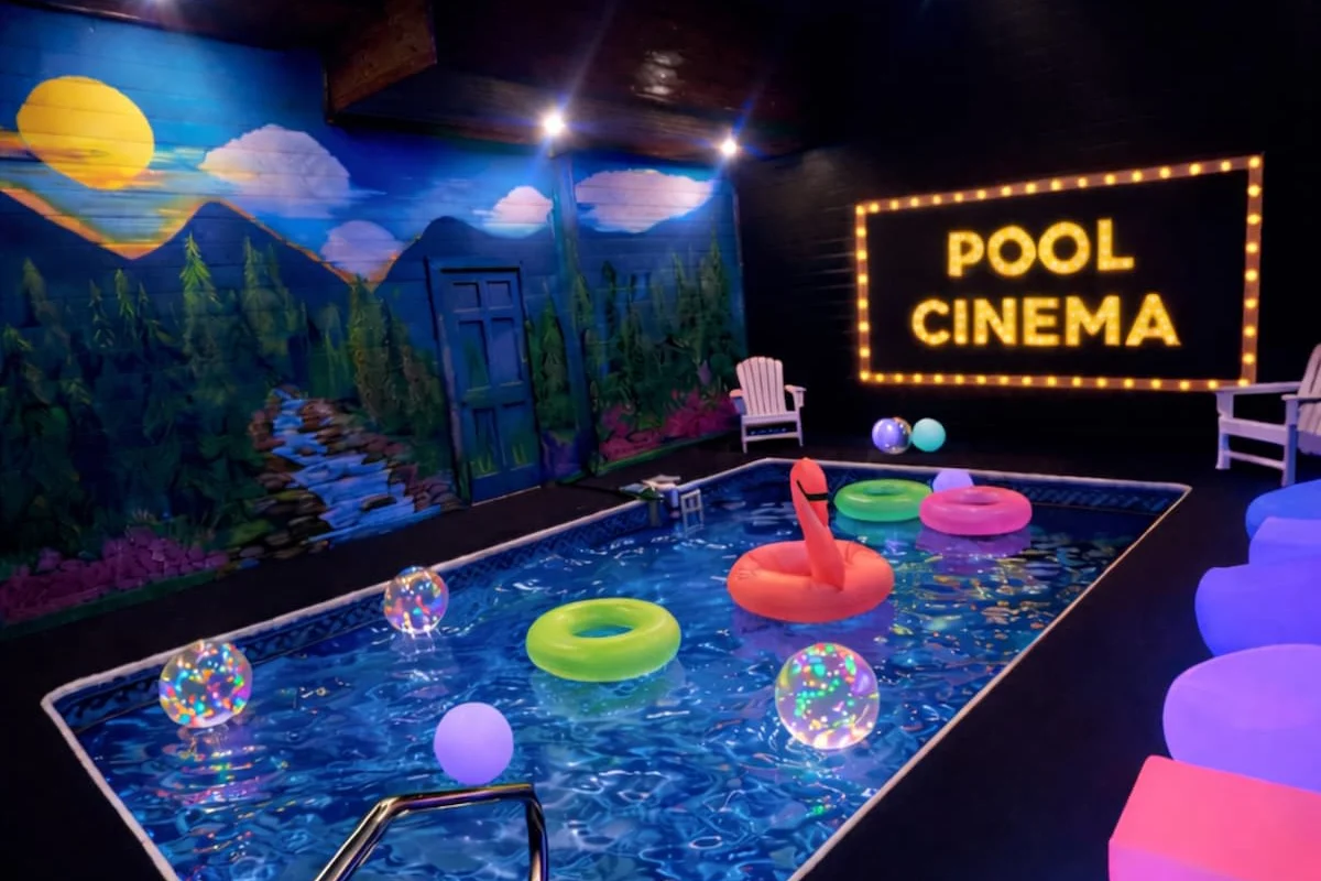Private indoor pool at Blackhawk Lodge with a POOL CINEMA sign and painted mountain mural
