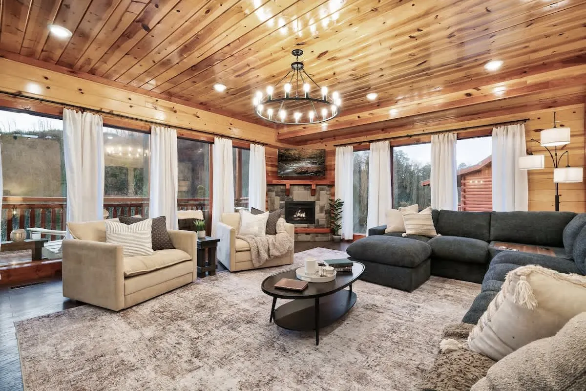 Great room at Blackhawk Lodge with a stone fireplace, chandelier and wall of windows
