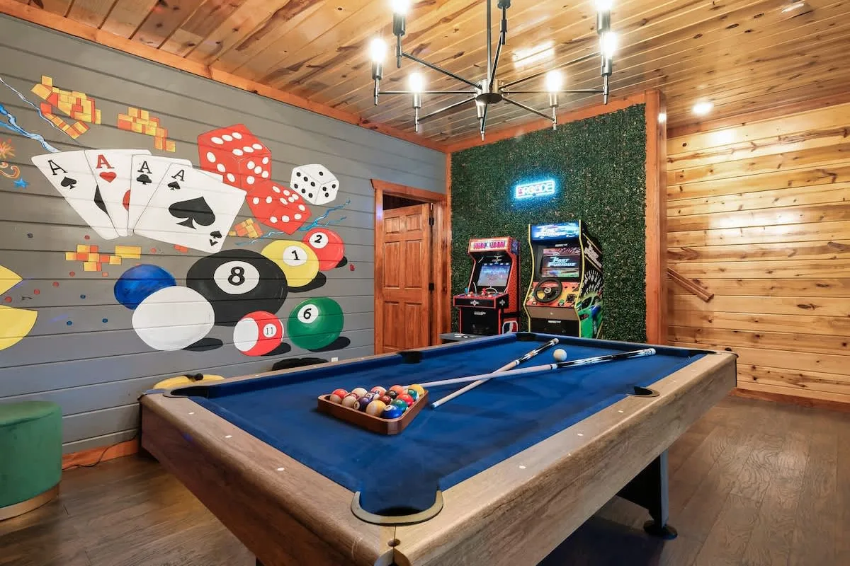 Game room at Blackhawk Lodge with a pool table, arcade cabinets and billiards mural