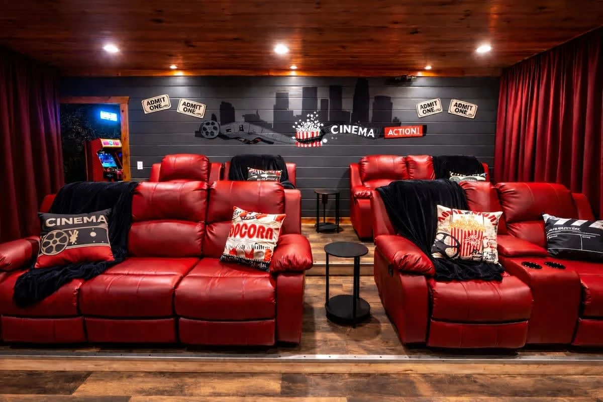Cinema seating at Blackhawk Lodge with red recliners and a painted skyline wall