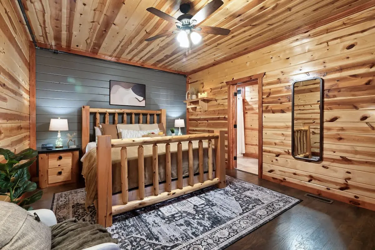 Bedroom at Blackhawk Lodge with a log bed frame and knotty pine walls