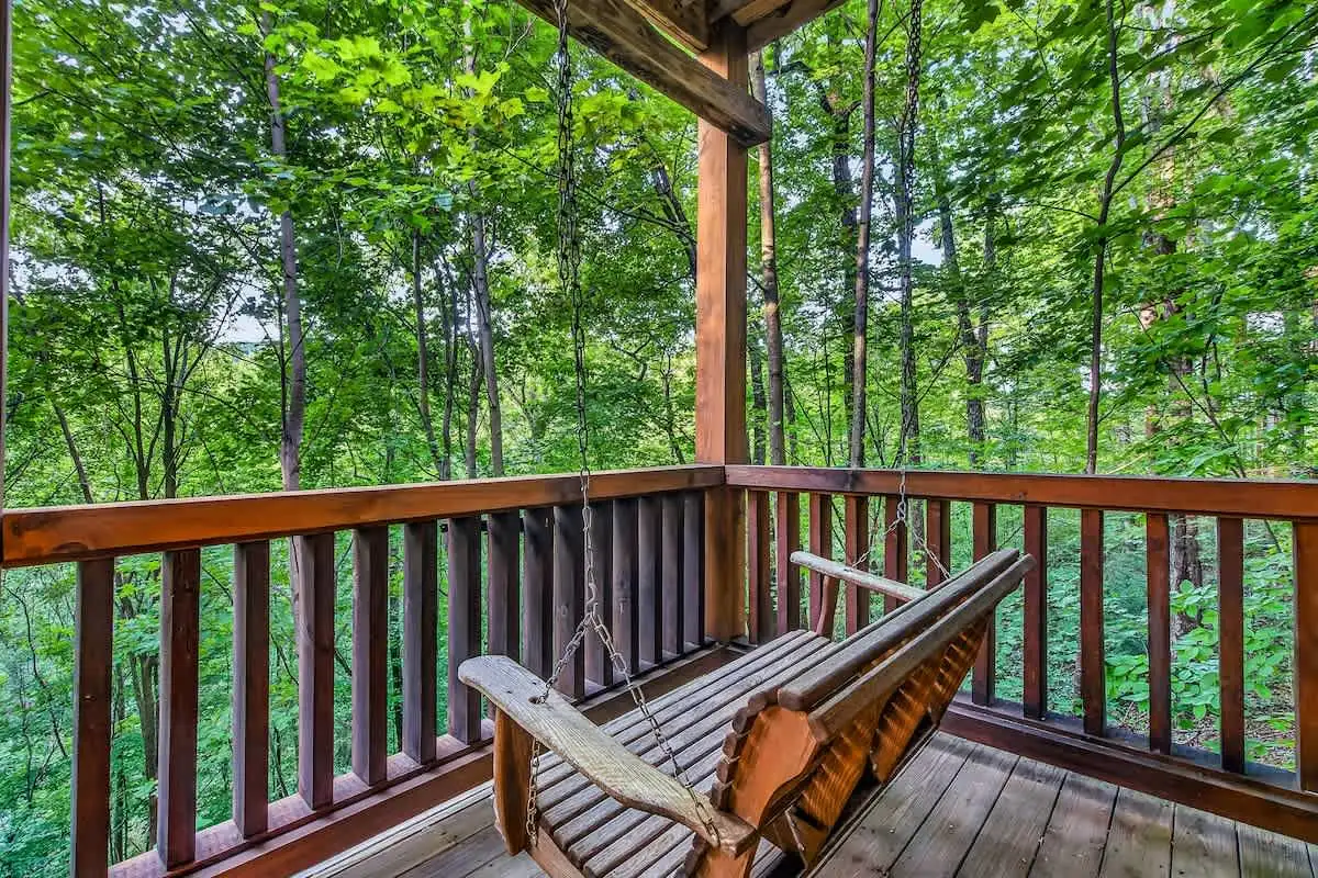 Porch swing on the wooded back deck at Break Point Lodge