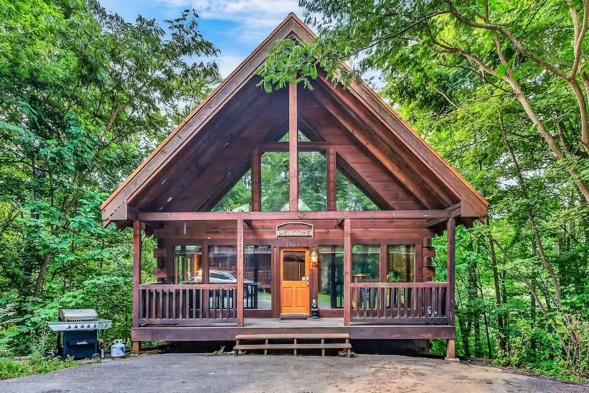 Break Point Lodge front exterior in daylight — A-frame cabin with a full-width deck
