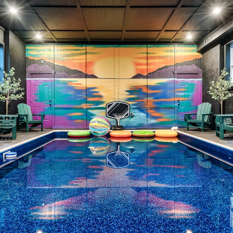 Indoor pool with a painted sunset mural