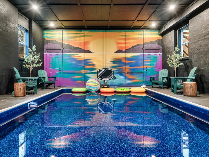 Indoor pool with a painted sunset mural
