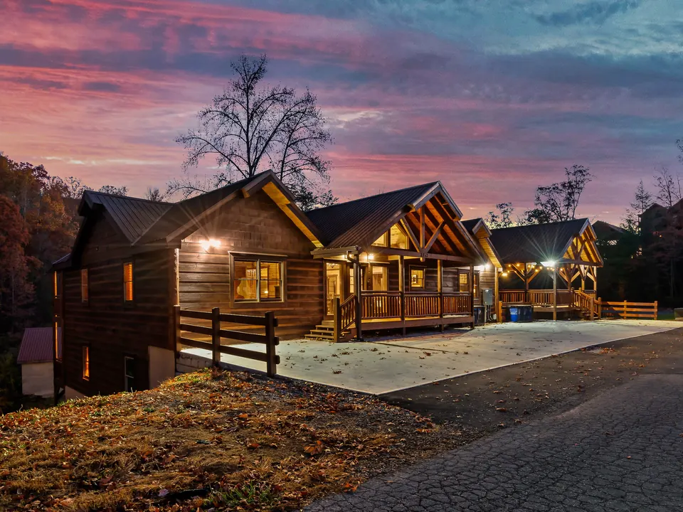 Log cabin at twilight under a pink sky